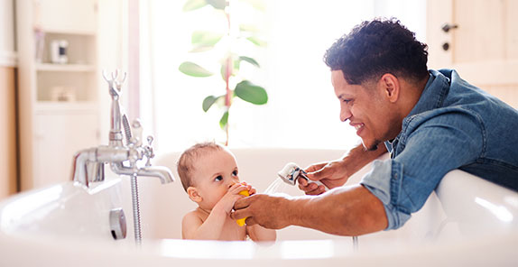 Parent giving his baby a bath